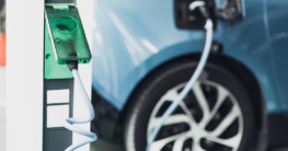 Blaues Elektrofahrzeug an einer Aufladestation - Steuern sparen mit einem Elektroauto